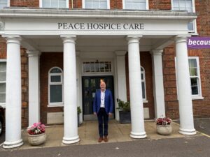 Stewart MArks photographed in front of Peace Hospice building