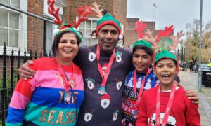 Family wearing antler headbands and medals after Rudolph Run 2022